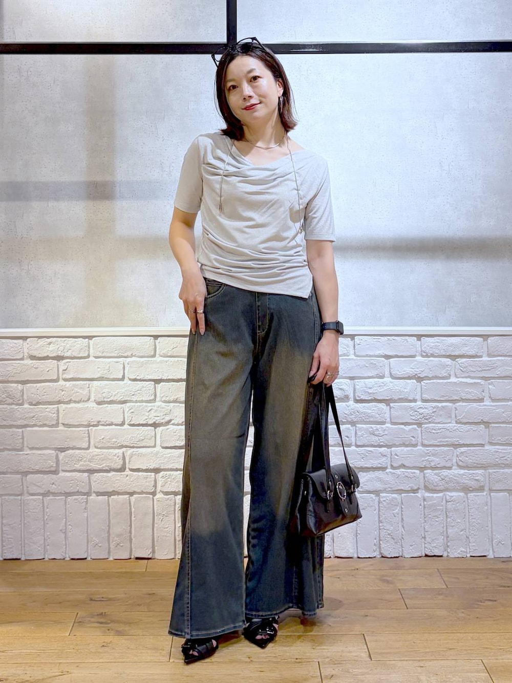 グリーン系のデニムパンツ、ブラック系のサンダル、ベージュ系のTシャツ/カットソーを着用したレディースの夏コーディネートの1枚目の写真