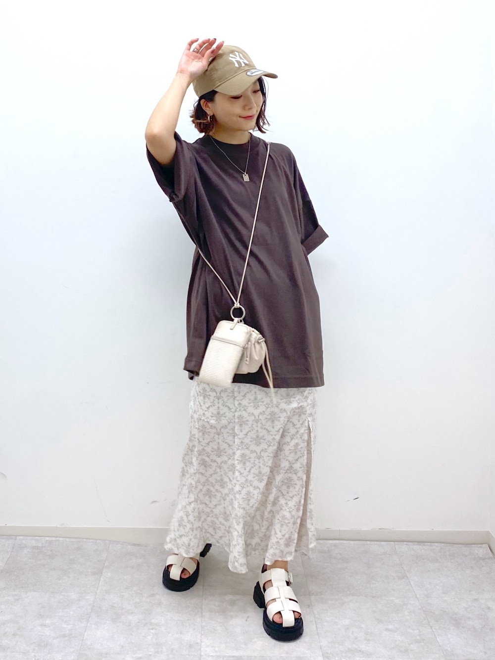 ブラウン系のTシャツ/カットソー、グレー系のスカート、ベージュ系のショルダーバッグを着用したレディースの夏コーディネートの1枚目の写真