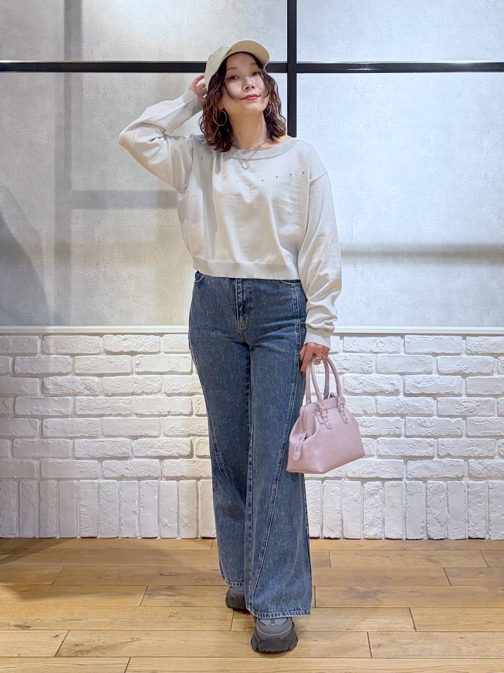 グレー系のスニーカー、ブルー系のデニムパンツ、ピンク系のハンドバッグを着用したレディースの冬コーディネートの1枚目の写真