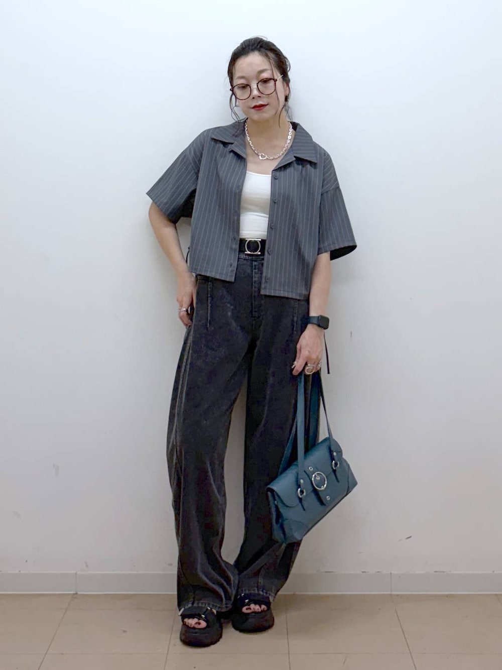 ブラック系のデニムパンツ、ブラック系のサンダル、グレー系のシャツ/ブラウスを着用したレディースの夏コーディネートの1枚目の写真