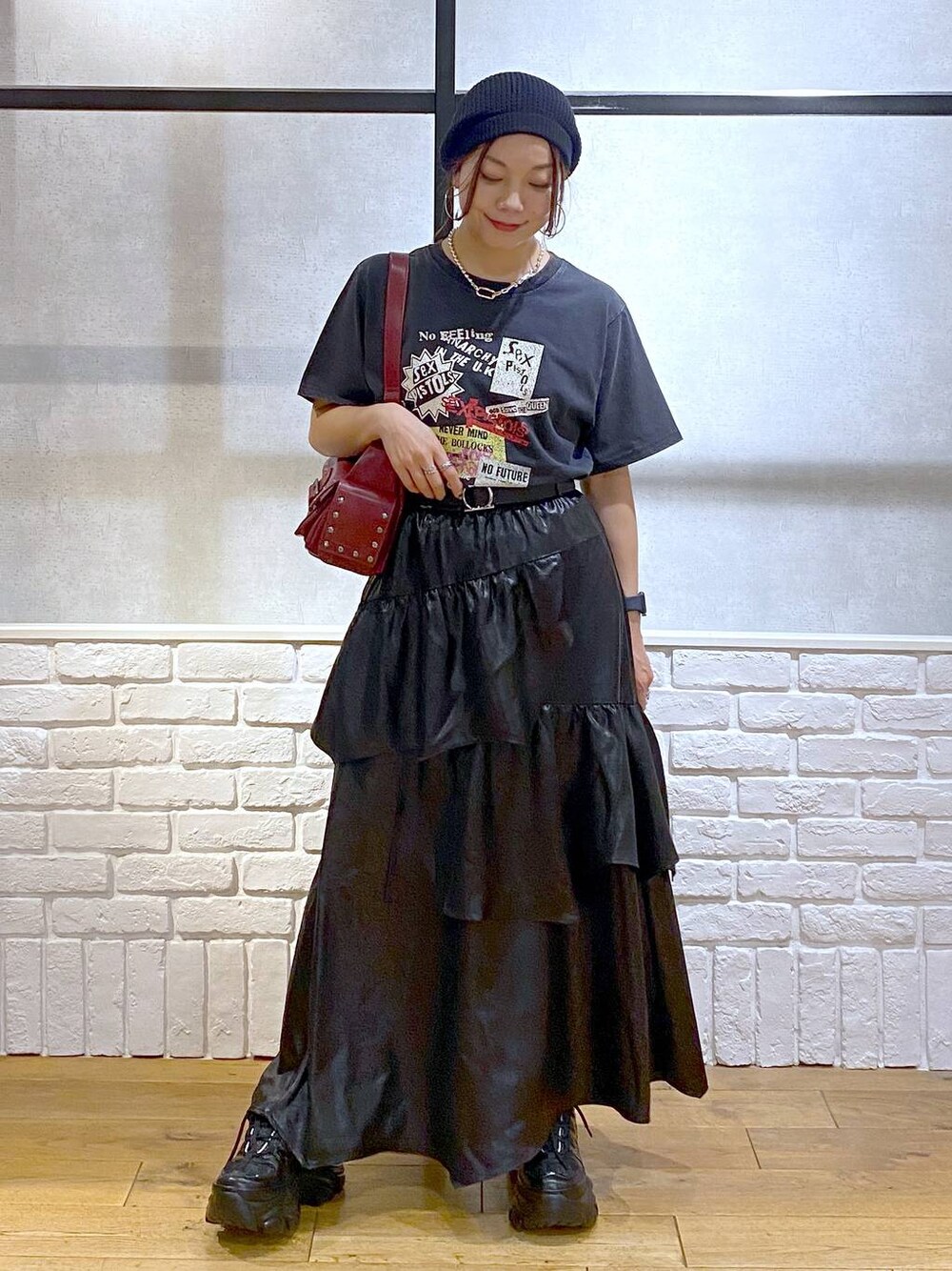 ブラック系のスニーカー、レッド系のショルダーバッグ、ブラック系のスカートを着用したレディースの夏コーディネートの1枚目の写真
