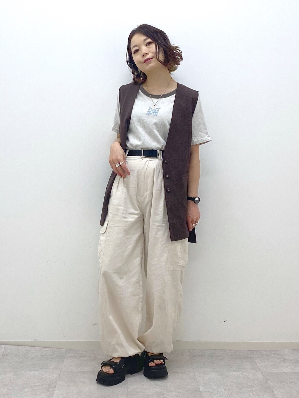 ホワイト系のカーゴパンツ、ブラック系のサンダル、ベージュ系のTシャツ/カットソーを着用したレディースの夏コーディネートの1枚目の写真