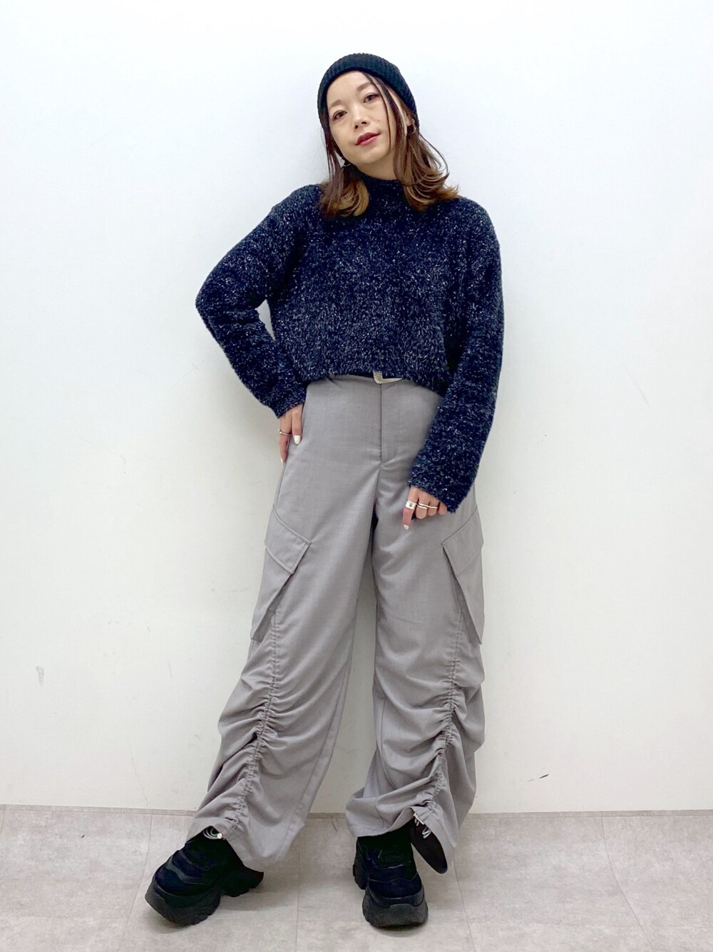 ブラック系のニット/セーター、ベージュ系のその他パンツ、ブラック系のスニーカーを着用したレディースの冬コーディネートの1枚目の写真