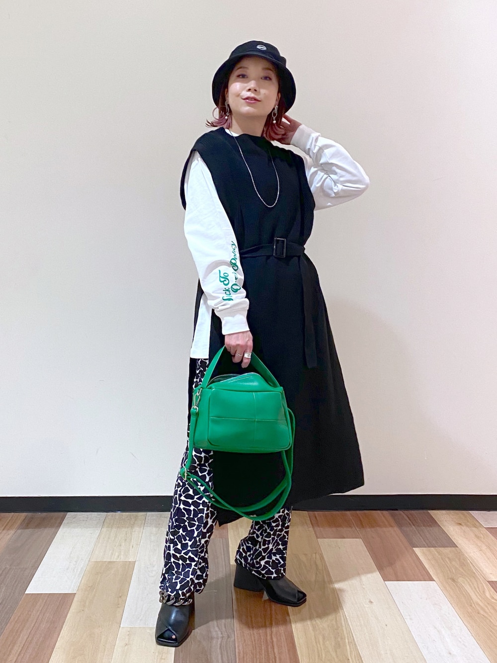 ブラック系のパンプス、ブラック系のワンピース、ホワイト系のTシャツ/カットソーを着用したレディースの冬コーディネートの1枚目の写真