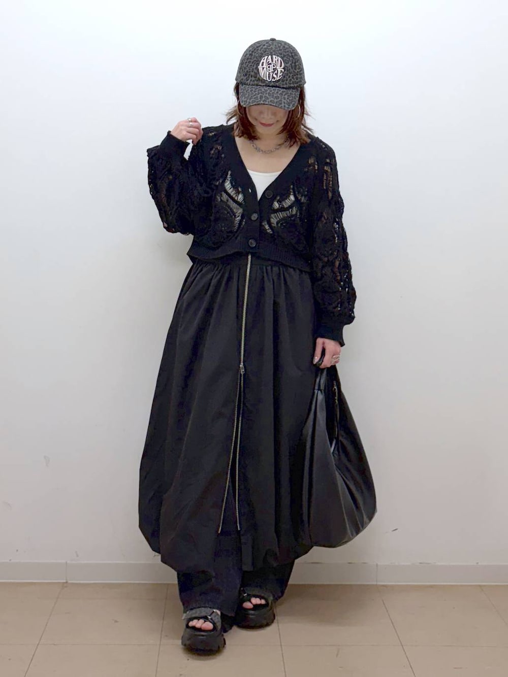 ホワイト系のキャミソール、ブラック系のカーディガン/ボレロ、ブラック系のトートバッグを着用したレディースの春コーディネートの1枚目の写真