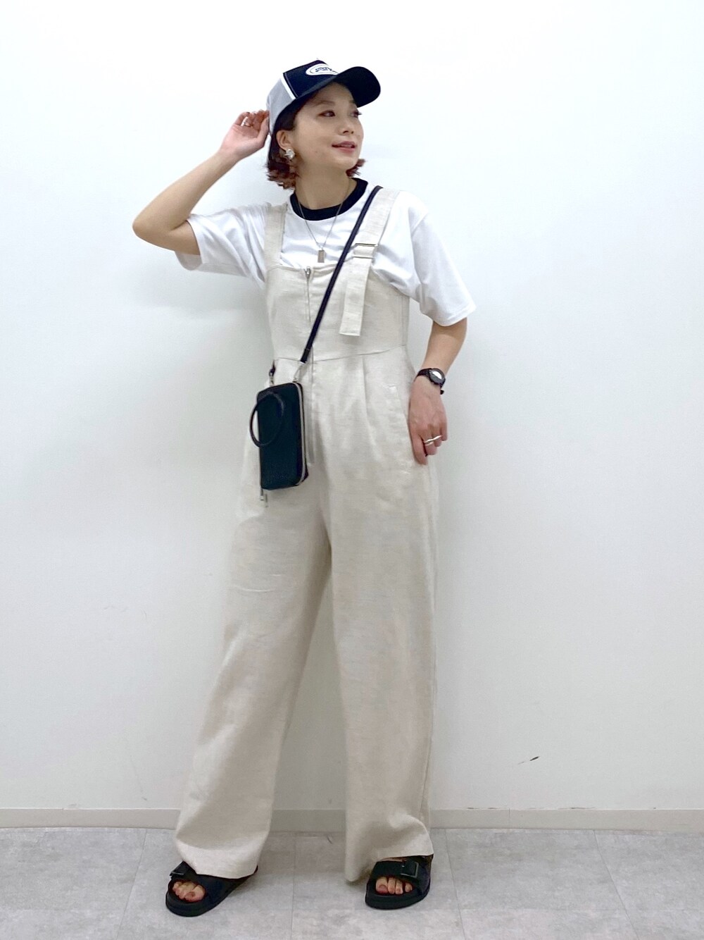 ホワイト系のサロペット/オーバーオール、ブラック系のサンダル、ホワイト系のTシャツ/カットソーを着用したレディースの夏コーディネートの1枚目の写真