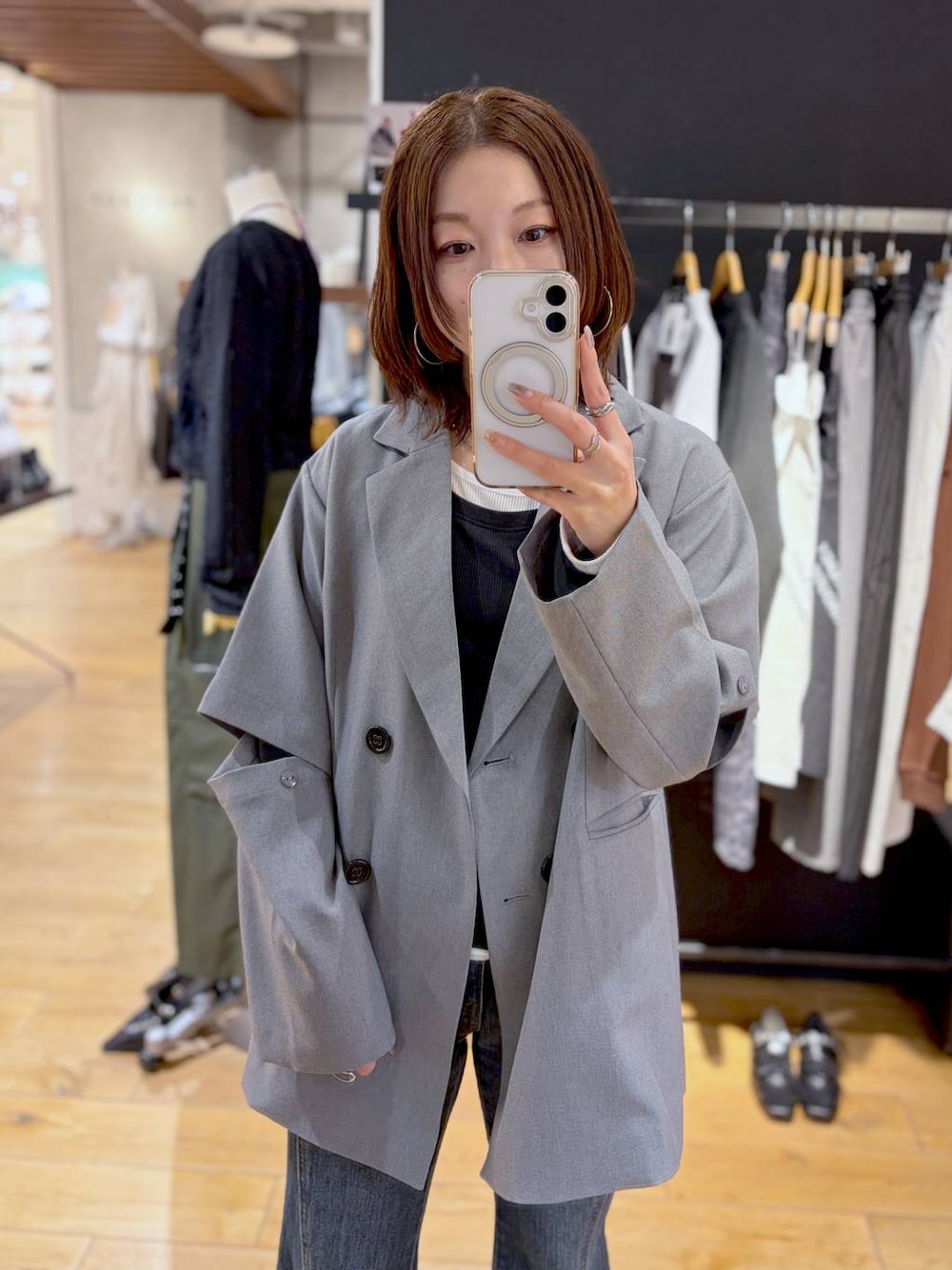 ブルー系のデニムパンツ、グレー系のテーラードジャケット、ブラック系のTシャツ/カットソーを着用したレディースの春コーディネートの1枚目の写真