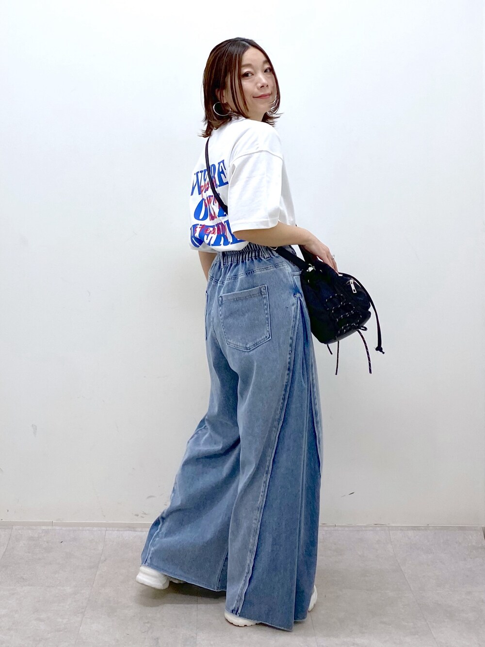 ホワイト系のTシャツ/カットソー、ブラック系のボディバッグ/ウエストポーチ、ブルー系のデニムパンツを着用したレディースの春コーディネートの1枚目の写真