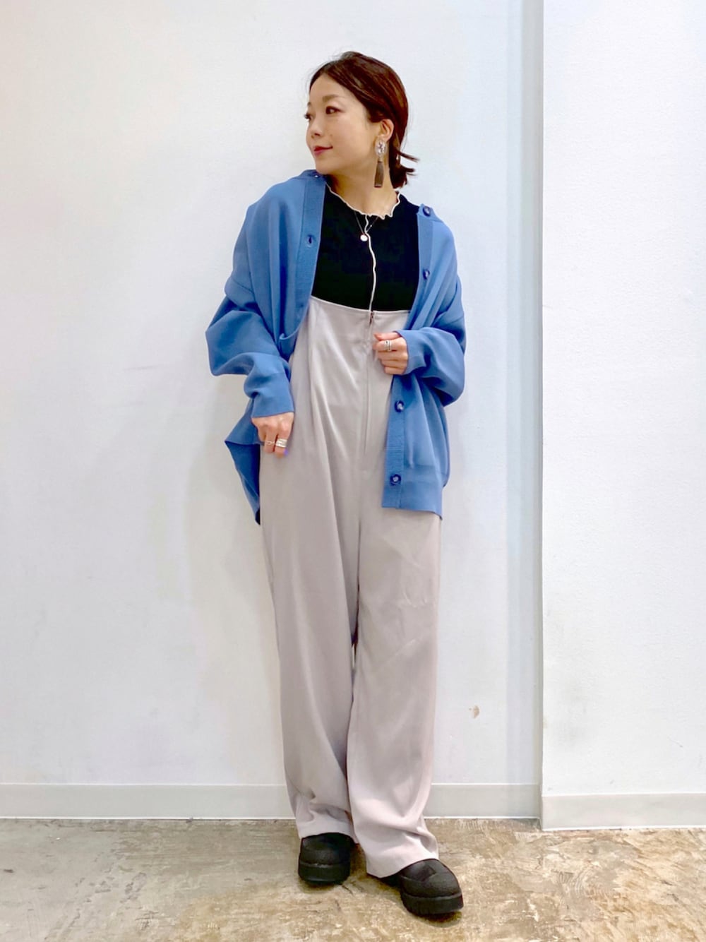 ブラック系のTシャツ/カットソー、ブルー系のカーディガン/ボレロ、ブラック系のブーツを着用したレディースの秋コーディネートの1枚目の写真