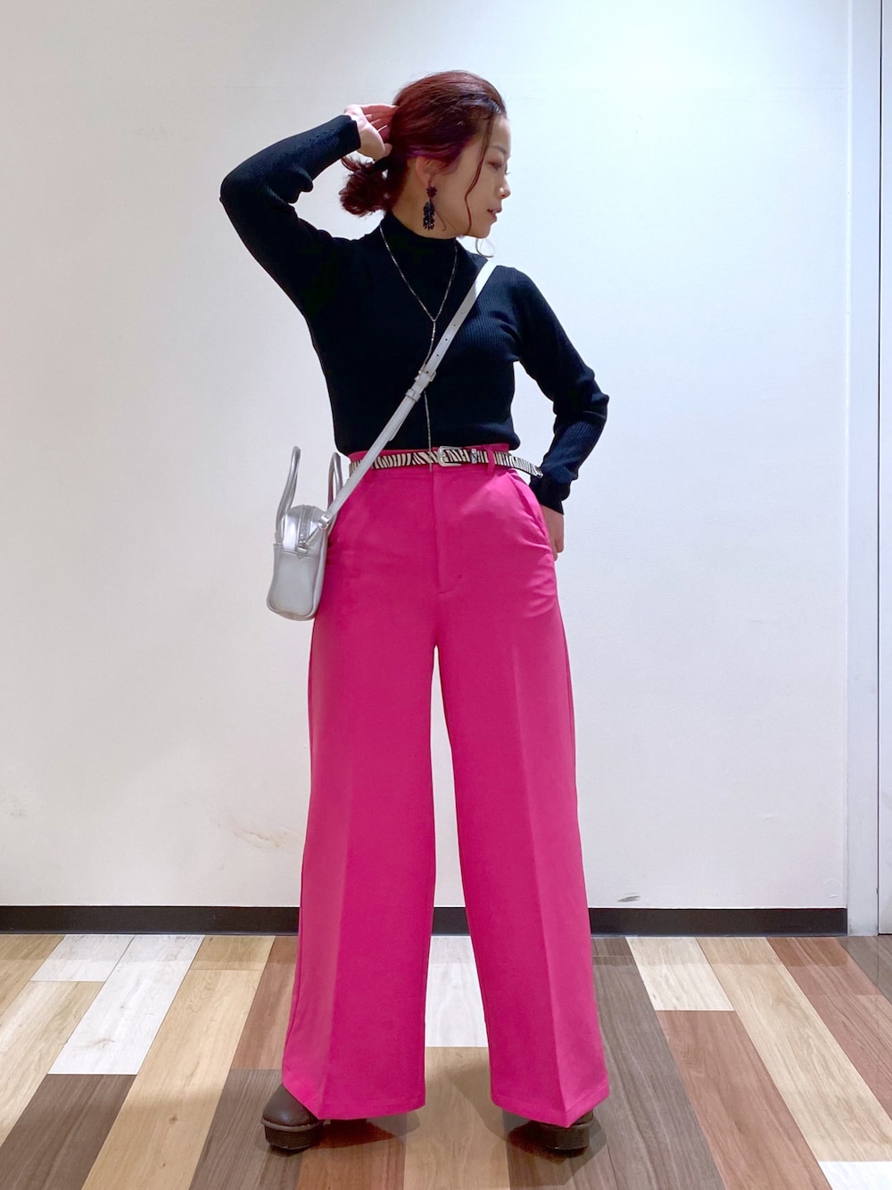 ブラック系のニット/セーター、シルバー系のボストンバッグ、ピンク系のスラックスを着用したレディースの冬コーディネートの1枚目の写真