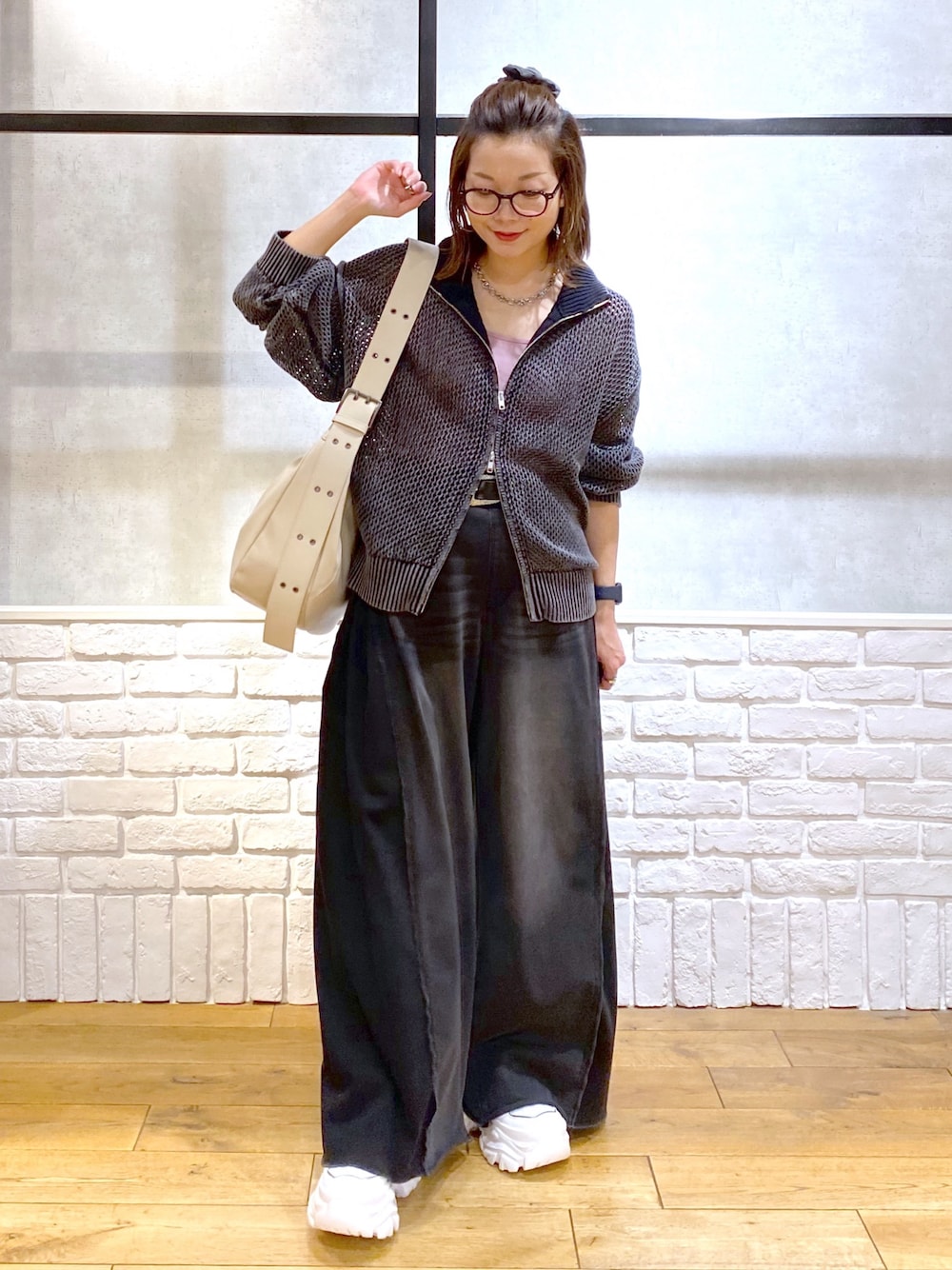ピンク系のキャミソール、ブラック系のニット/セーター、ブラック系のデニムパンツを着用したレディースの春コーディネートの1枚目の写真