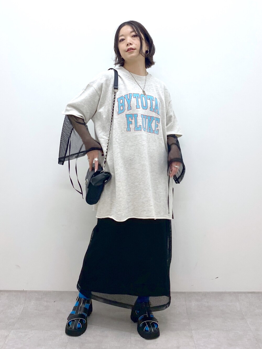 ベージュ系のトップス、ブラック系のワンピース/ドレス、ブラック系のサンダルを着用したレディースの春コーディネートの1枚目の写真