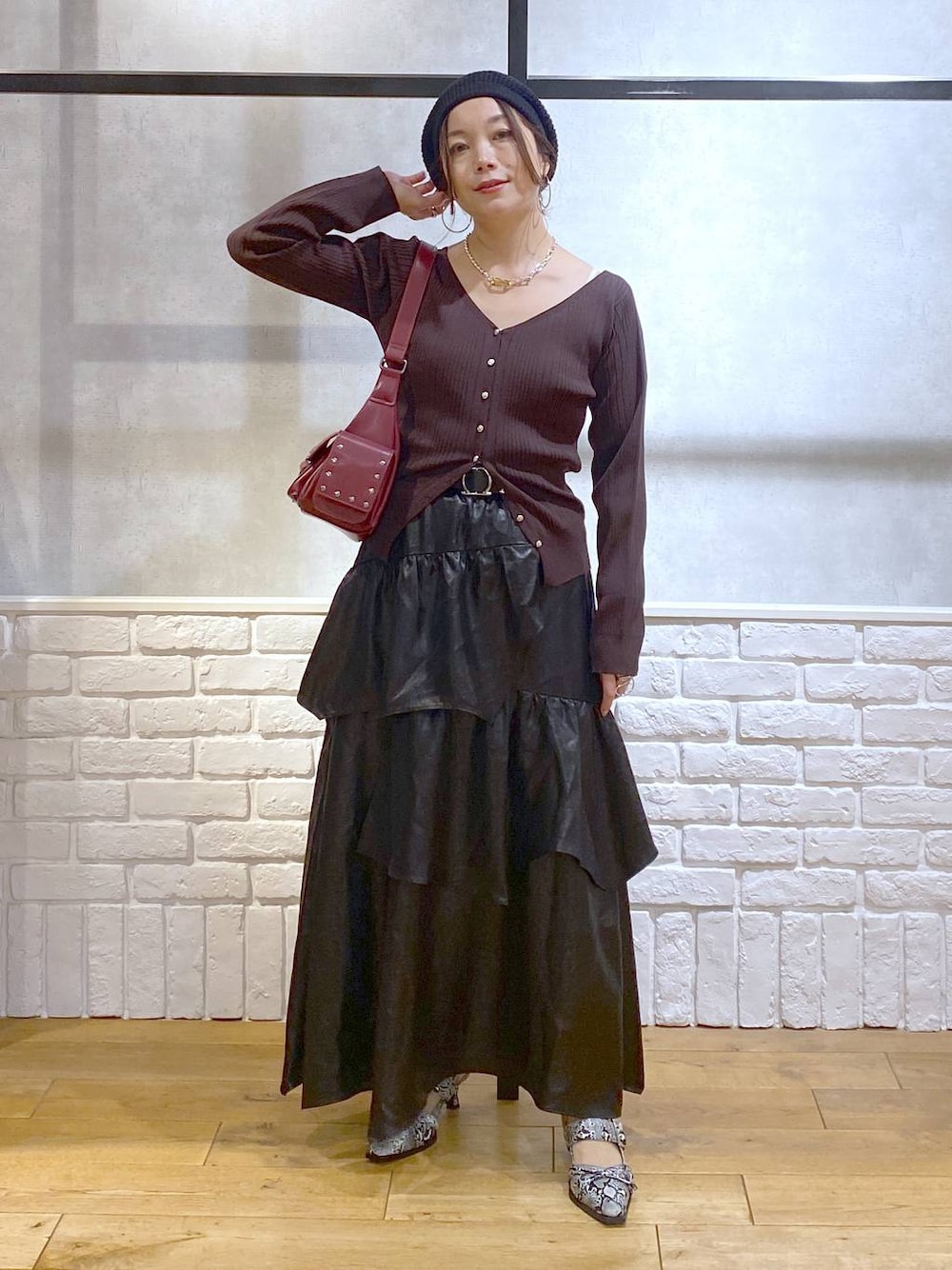 ホワイト系のパンプス、レッド系のショルダーバッグ、ブラック系のスカートを着用したレディースの夏コーディネートの1枚目の写真