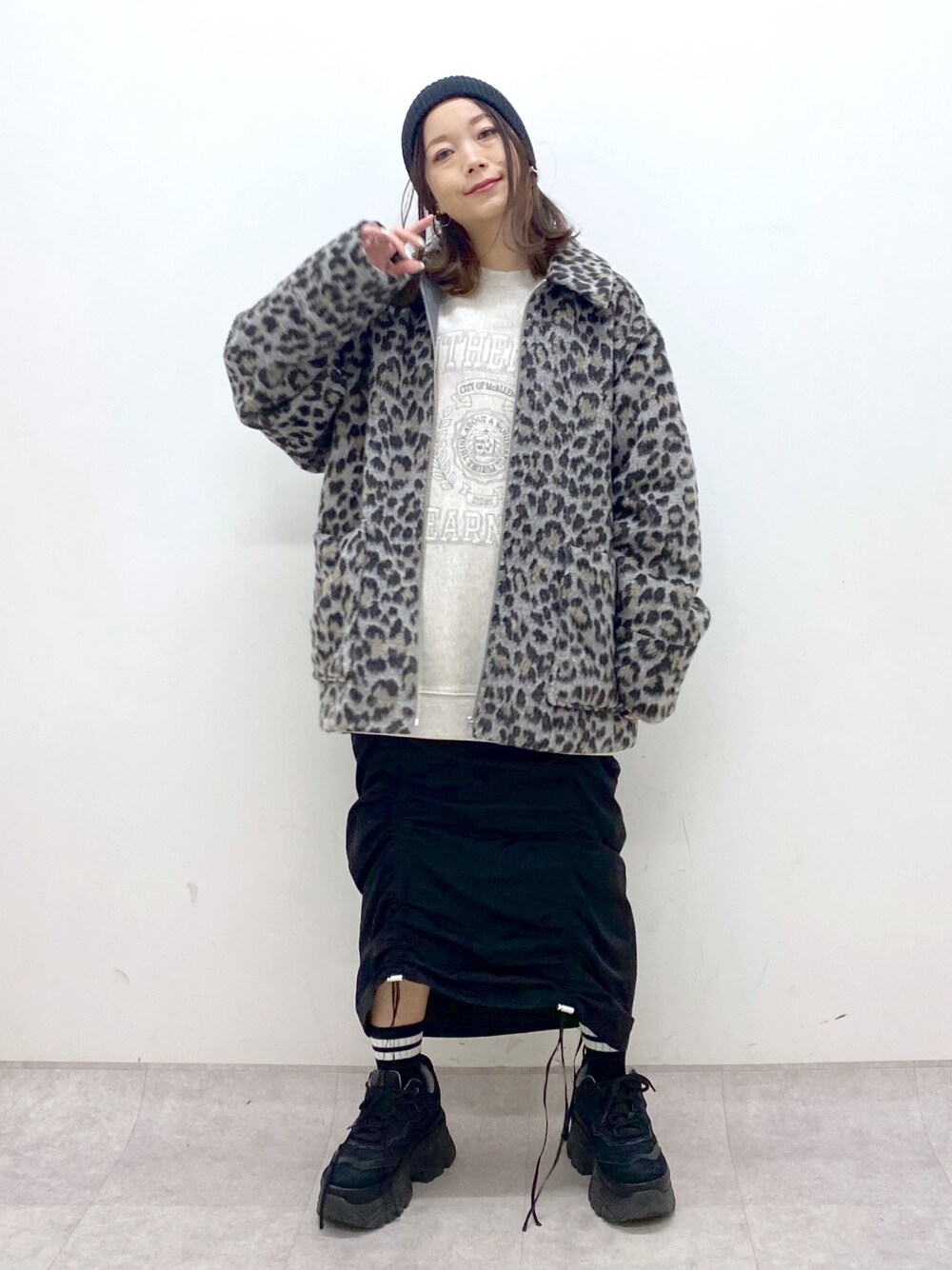 ベージュ系のスウェット、ブラック系のワンピース、ブラック系のスニーカーを着用したレディースの冬コーディネートの1枚目の写真