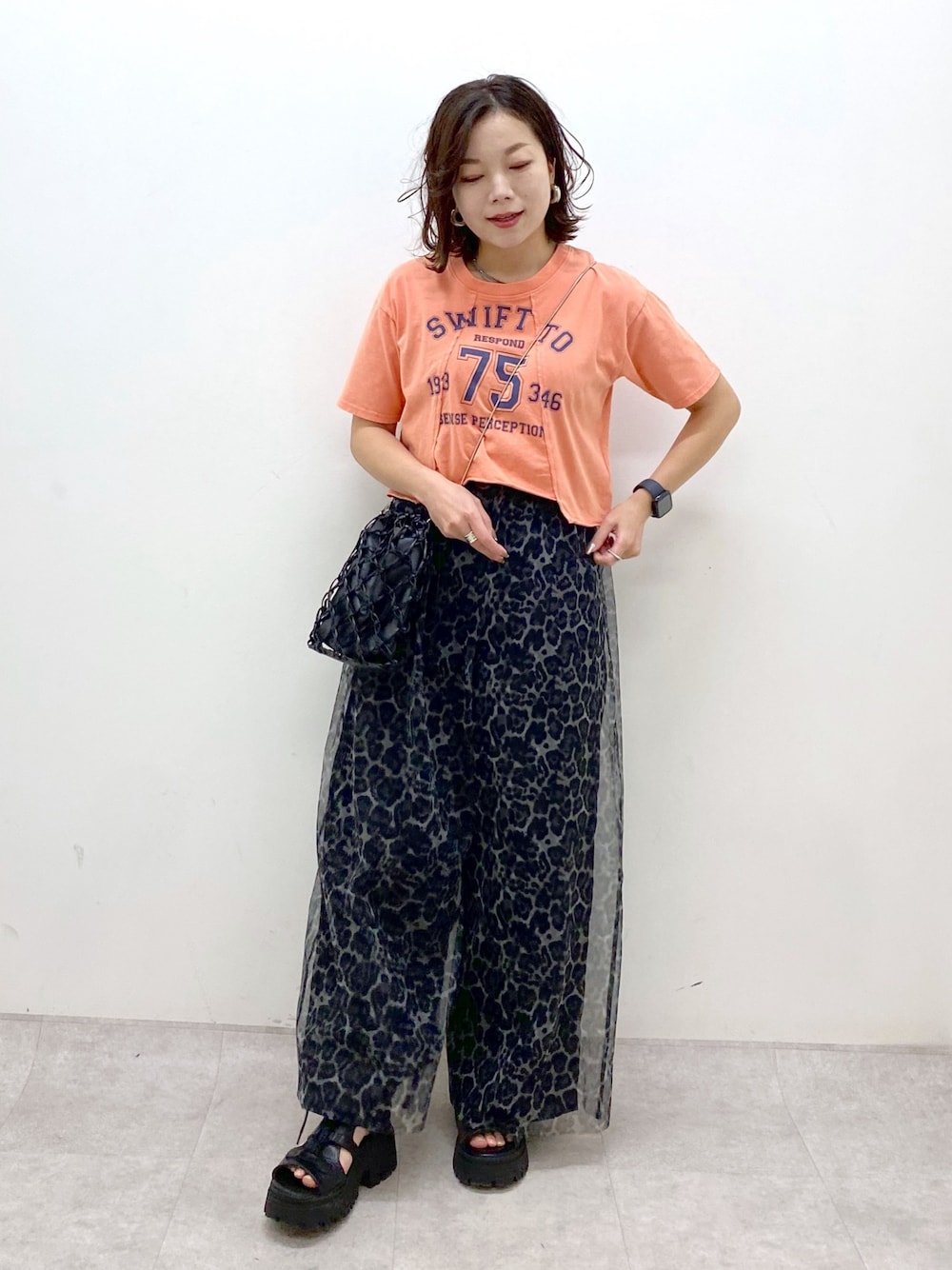 ピンク系のTシャツ/カットソー、グレー系のその他パンツ、ブラック系のサンダルを着用したレディースの春コーディネートの1枚目の写真