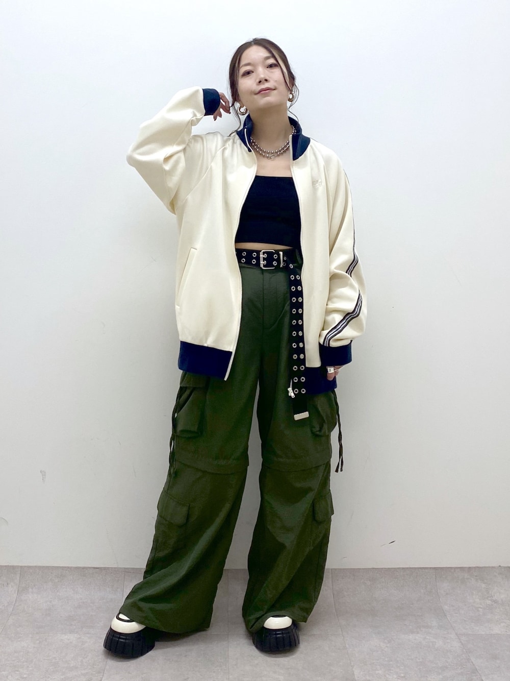 ブラック系のキャミソール、ホワイト系のセットアップ、グリーン系のカーゴパンツを着用したレディースの冬コーディネートの1枚目の写真