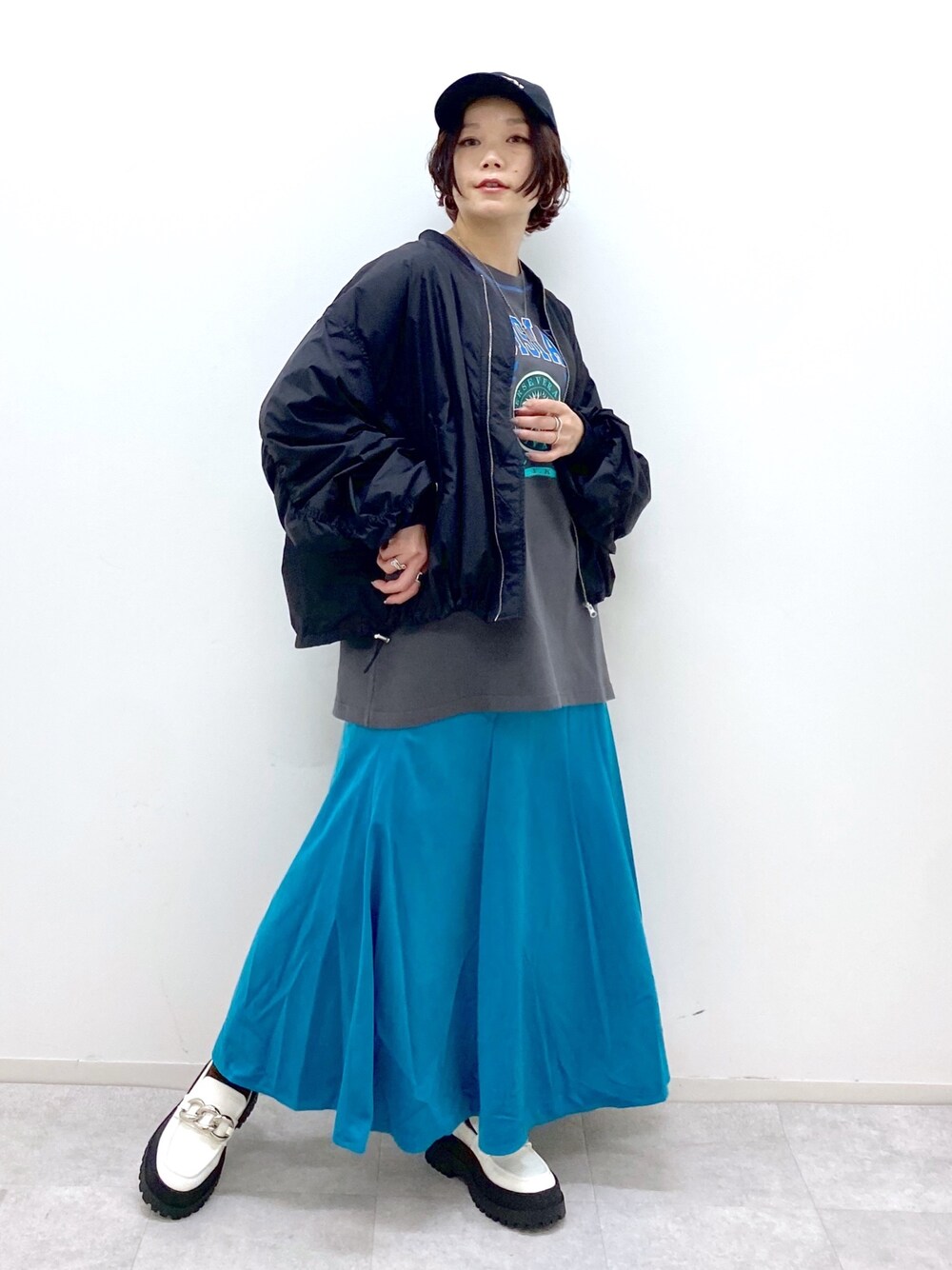 ブラック系のジャケット/アウター、ブラック系のトップス、グリーン系のスカートを着用したレディースの夏コーディネートの1枚目の写真