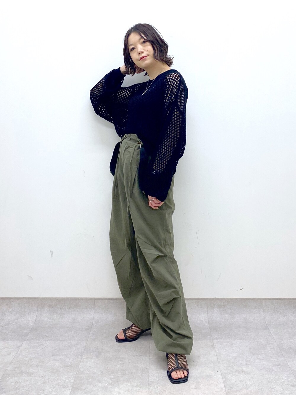 グリーン系のその他パンツ、ブラック系のシューズ、ブラック系のニット/セーターを着用したレディースの春コーディネートの1枚目の写真