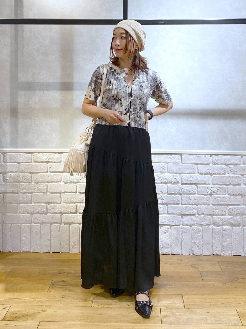 ブラック系のパンプス、ブラック系のスカート、ホワイト系のショルダーバッグを着用したレディースの夏コーディネートの1枚目の写真