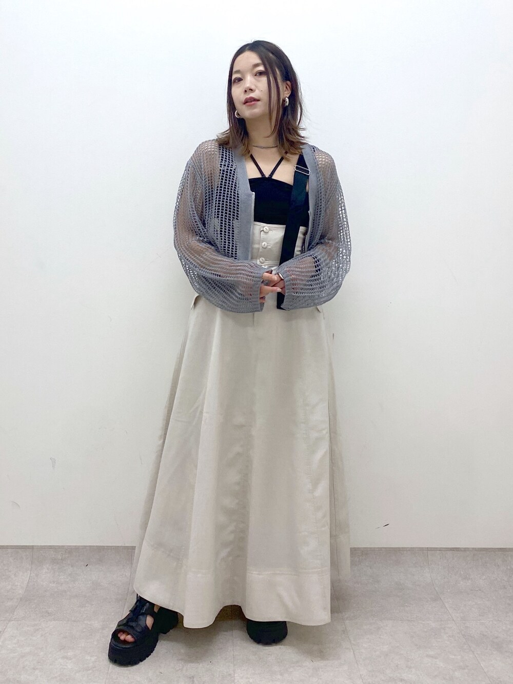 ブラック系のキャミソール、グレー系のカーディガン/ボレロ、ベージュ系のスカートを着用したレディースの春コーディネートの1枚目の写真