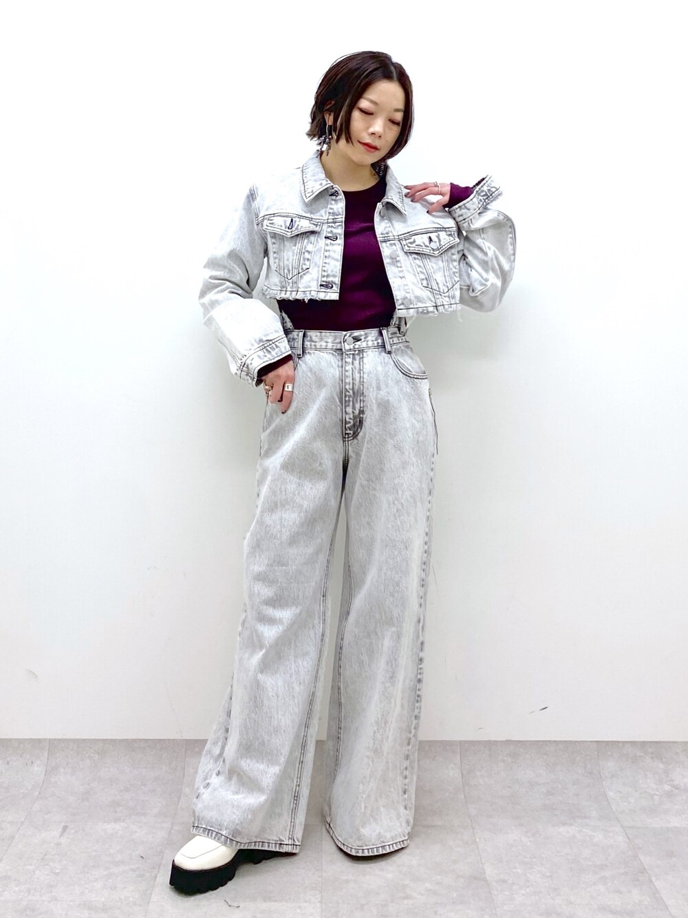 グレー系のデニムパンツ、グレー系のデニムジャケット、レッド系のTシャツ/カットソーを着用したレディースの冬コーディネートの1枚目の写真