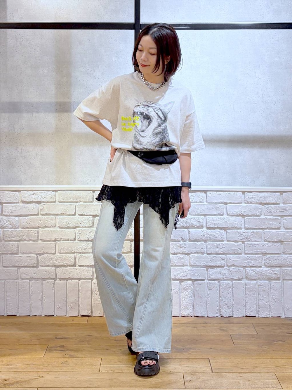 グレー系のTシャツ/カットソー、ブルー系のデニムパンツ、ブラック系のボディバッグ/ウエストポーチを着用したレディースの春コーディネートの1枚目の写真
