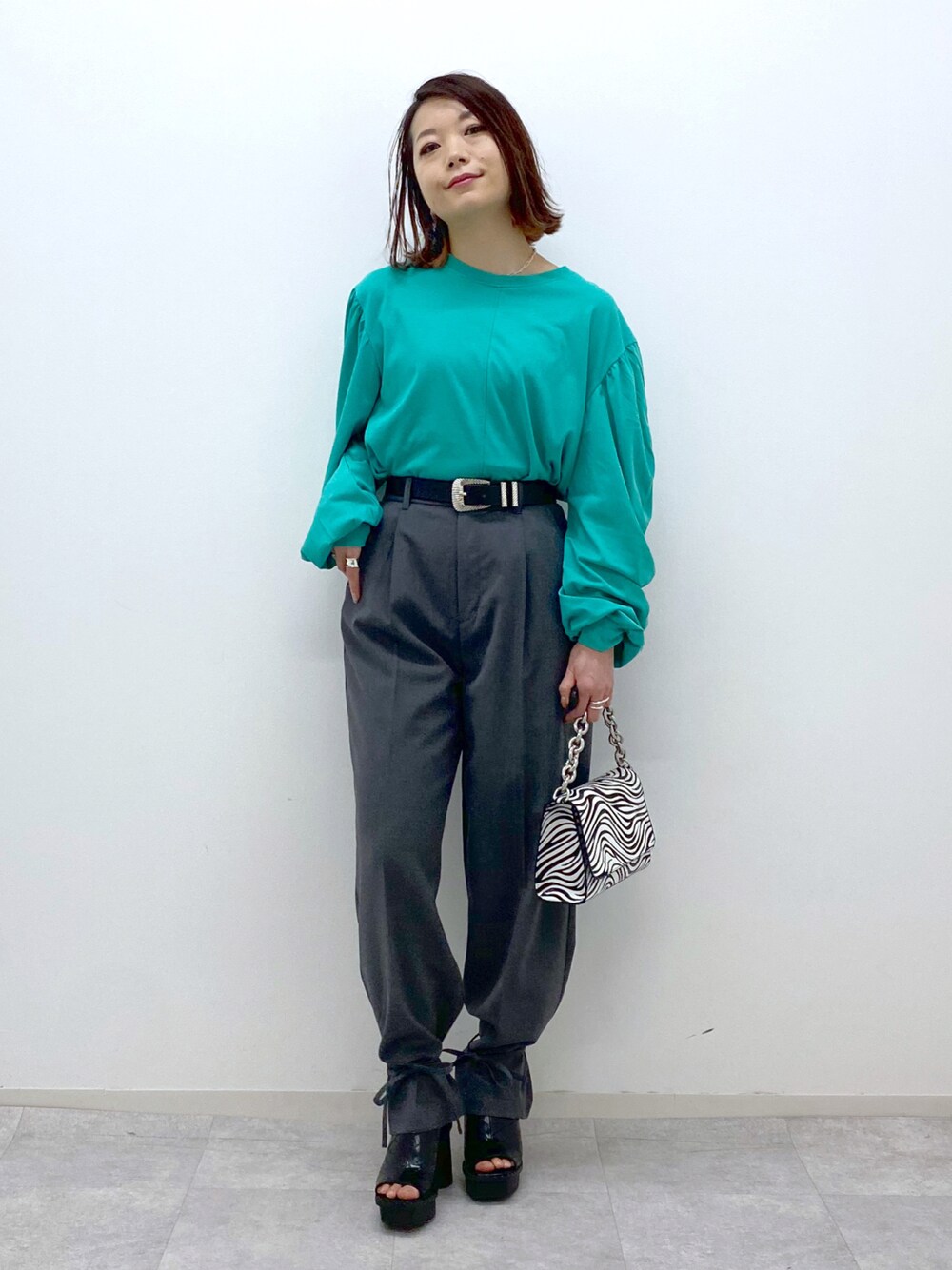 グリーン系のTシャツ/カットソー、グレー系のその他パンツ、その他のショルダーバッグを着用したレディースの春コーディネートの1枚目の写真