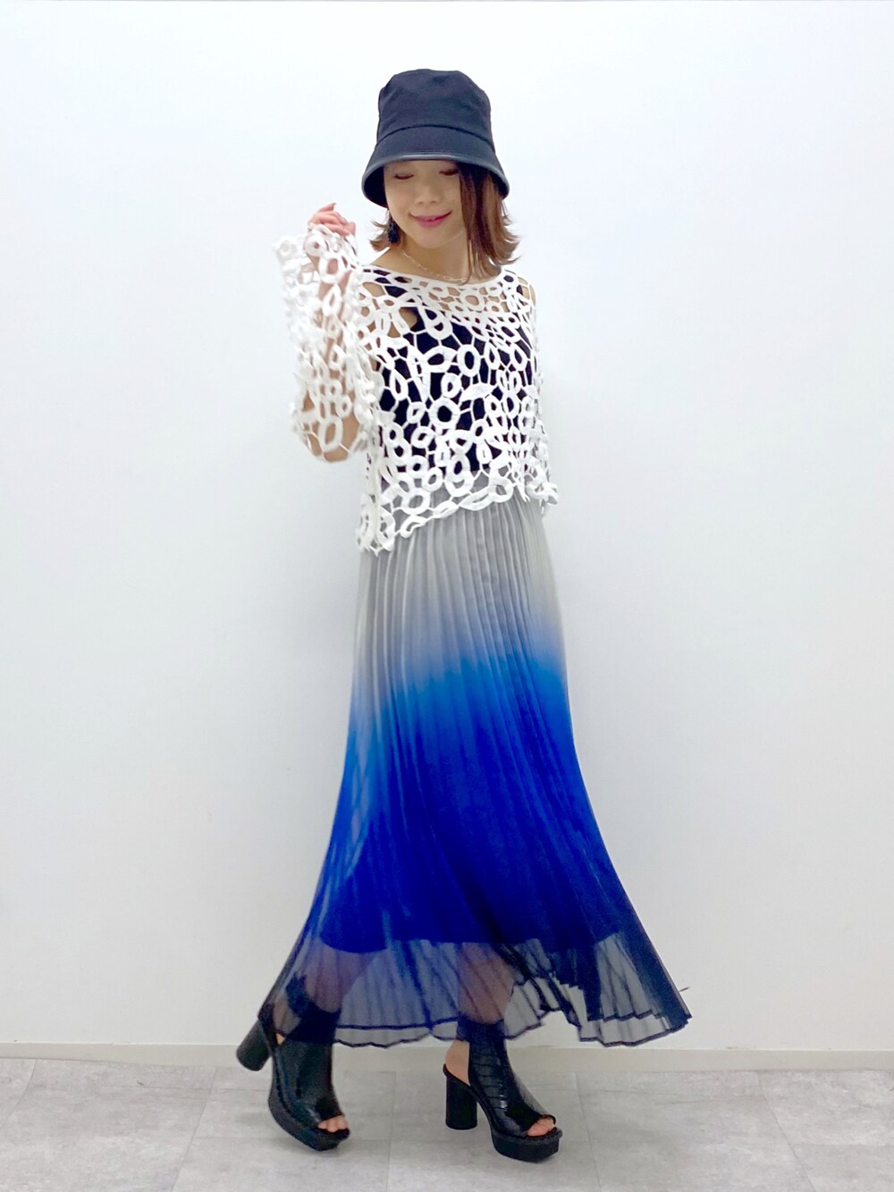 ブルー系のスカート、ブラック系のタンクトップ、ブラック系のサンダルを着用したレディースの春コーディネートの1枚目の写真