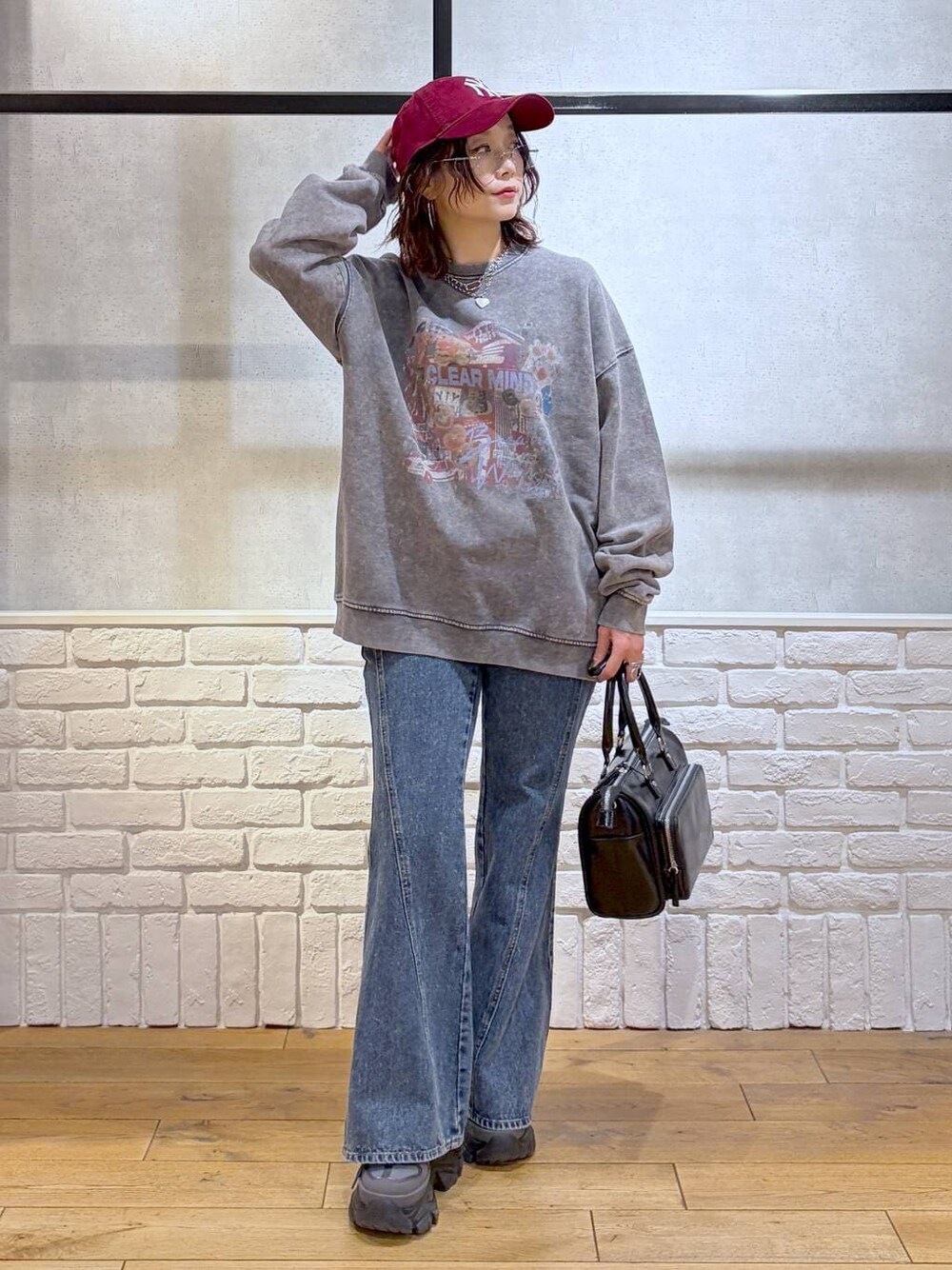 グレー系のスニーカー、ブルー系のデニムパンツ、ブラック系のショルダーバッグを着用したレディースの冬コーディネートの1枚目の写真