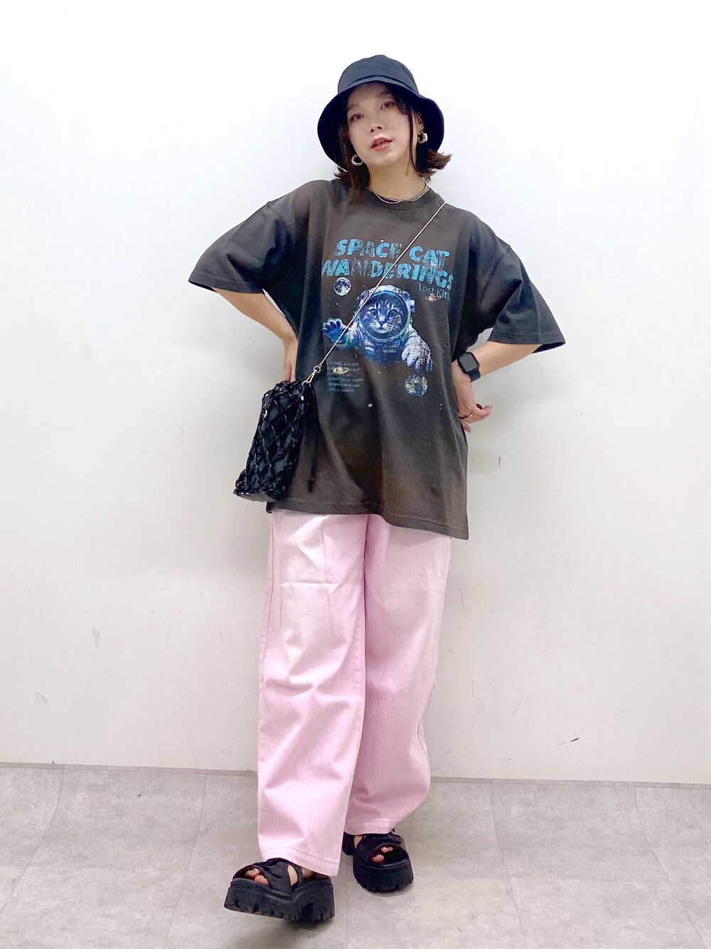 ピンク系のデニムパンツ、ブラック系のサンダル、ブラック系のショルダーバッグを着用したレディースの夏コーディネートの1枚目の写真