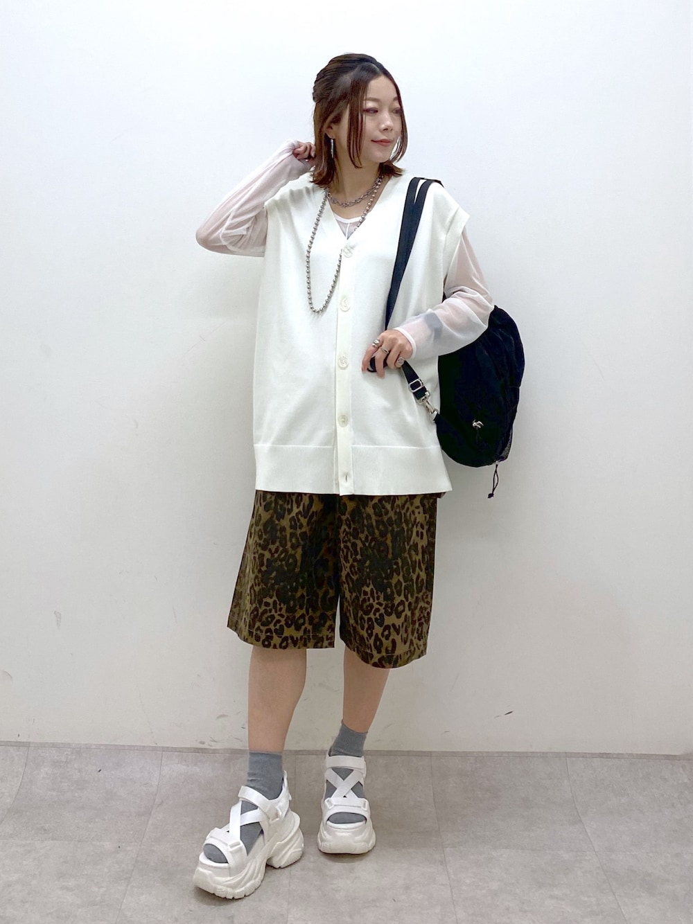 ホワイト系のカーディガン/ボレロ、ホワイト系のTシャツ/カットソー、ブラック系のバックパック/リュックを着用したレディースの春コーディネートの1枚目の写真