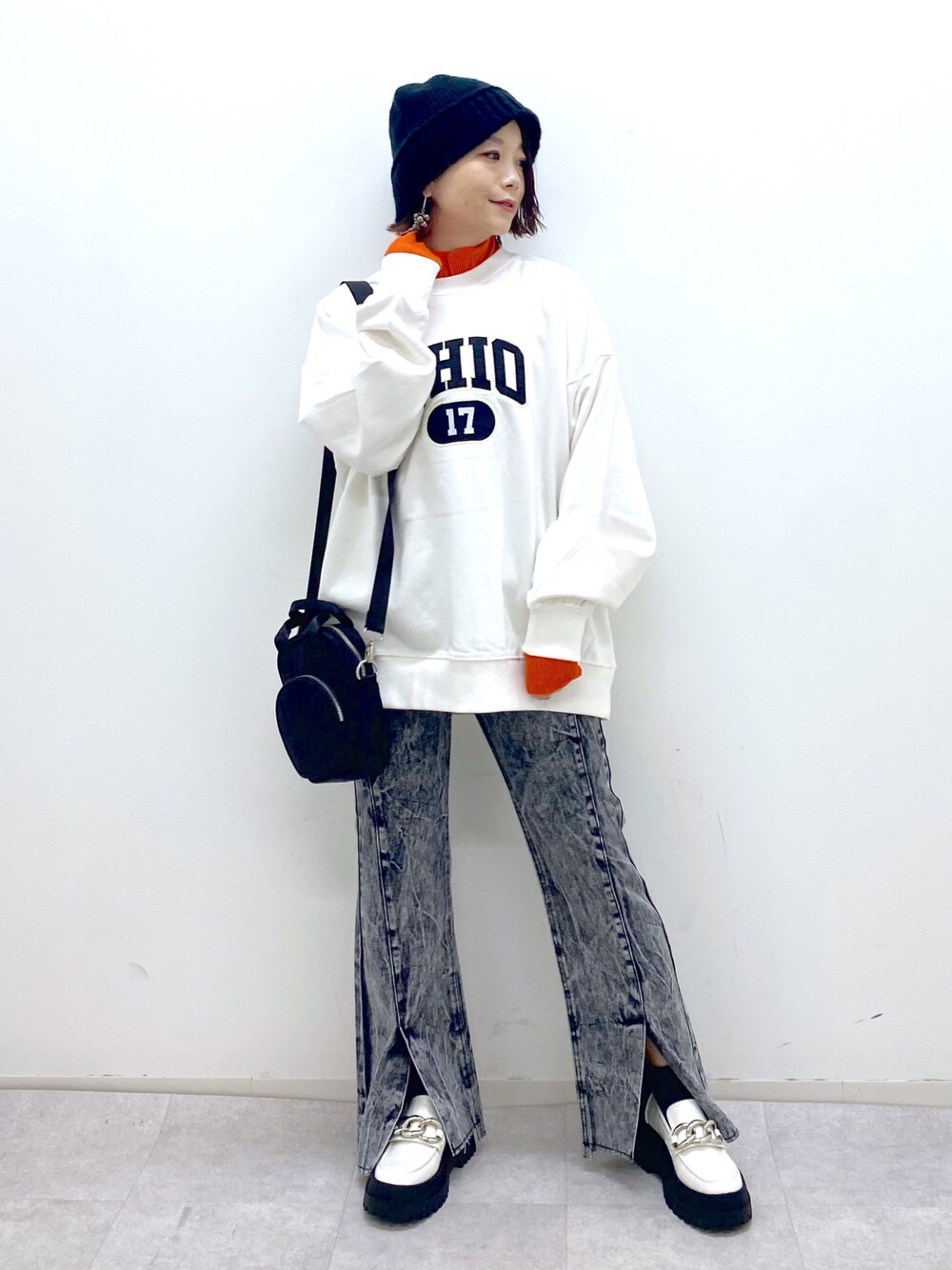 ホワイト系のトップス、オレンジ系のトップス、ブラック系のショルダーバッグを着用したレディースの秋コーディネートの1枚目の写真