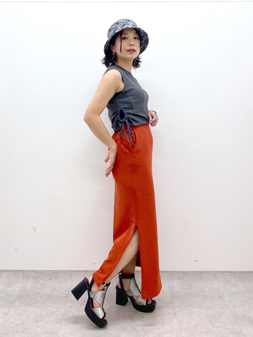 ホワイト系のサンダル、オレンジ系のスカート、グレー系のTシャツ/カットソーを着用したレディースの夏コーディネートの1枚目の写真