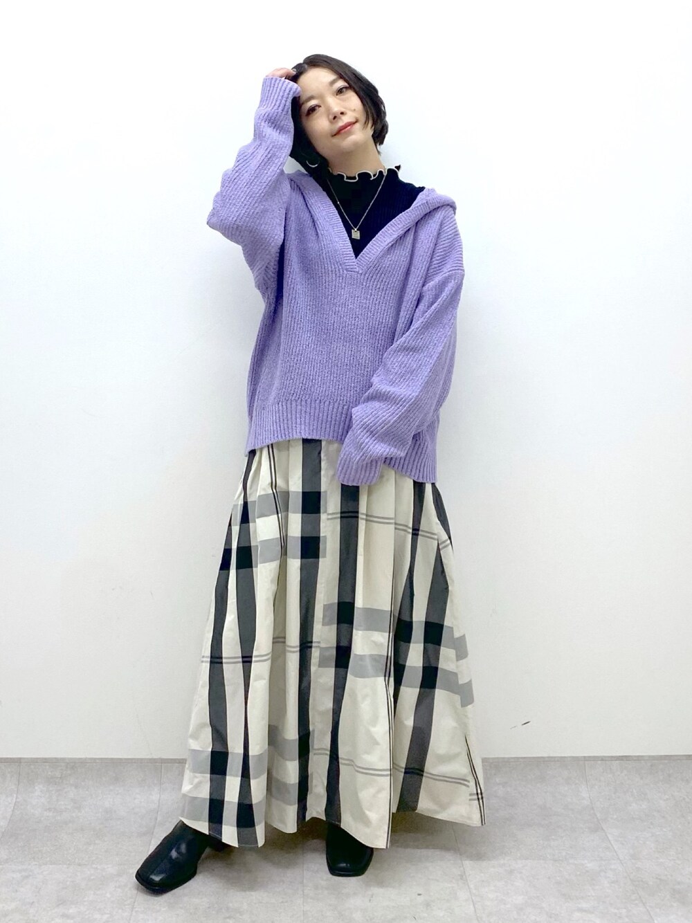 ホワイト系のスカート、パープル系のニット/セーター、ブラック系のニット/セーターを着用したレディースの冬コーディネートの1枚目の写真