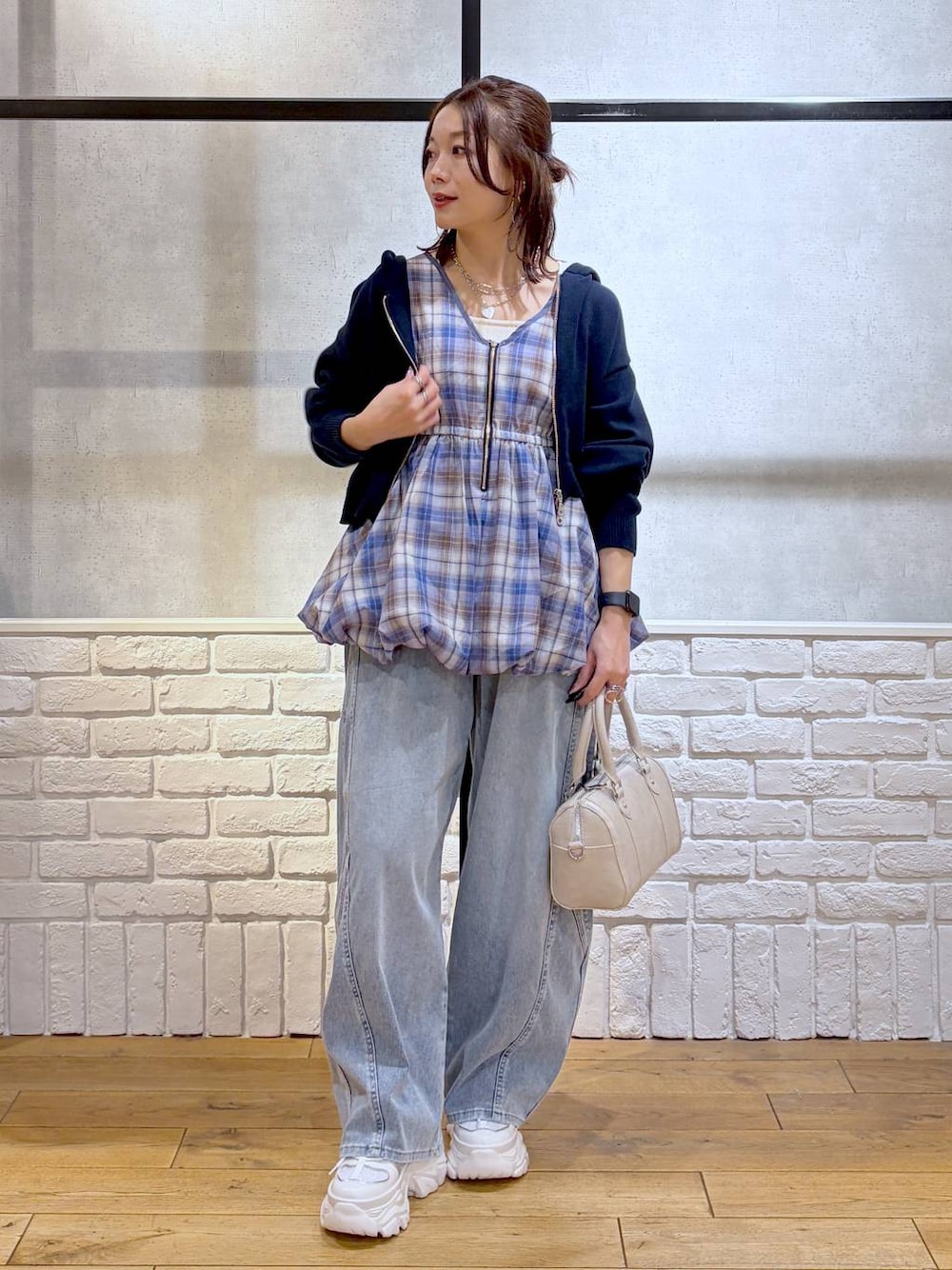 ホワイト系のスニーカー、ホワイト系のボストンバッグ、ブルー系のパーカーを着用したレディースの春コーディネートの1枚目の写真