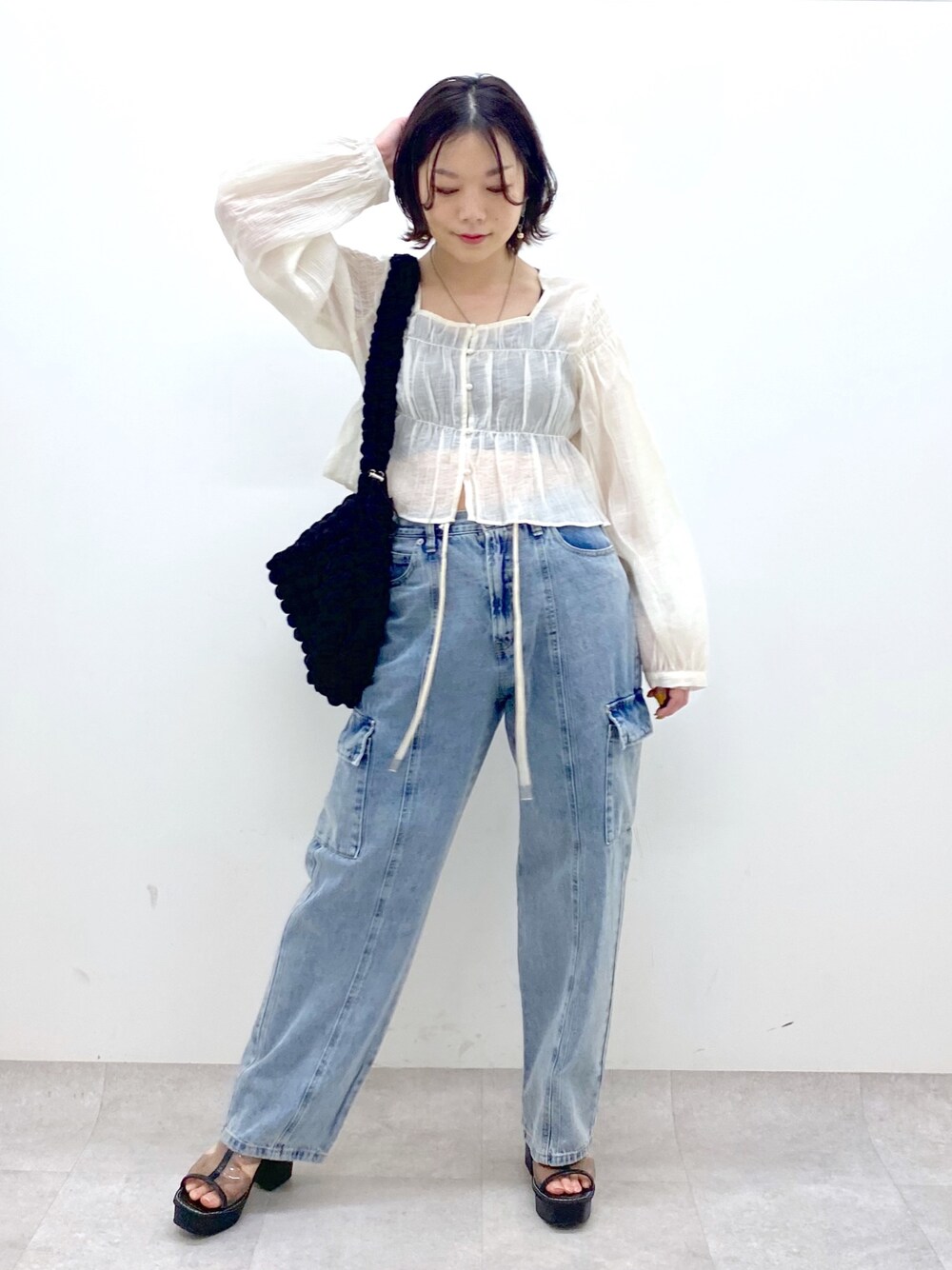 ホワイト系のシャツ/ブラウス、ブルー系のデニムパンツ、ブラック系のバッグを着用したレディースの春コーディネートの1枚目の写真