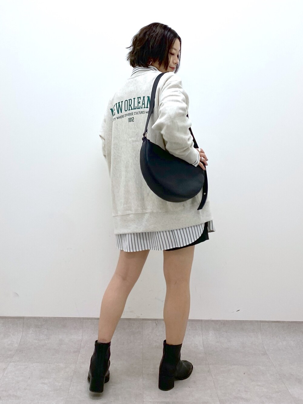 ブラック系のショルダーバッグ、ブラック系のシューズ、ベージュ系のトップスを着用したレディースの冬コーディネートの1枚目の写真