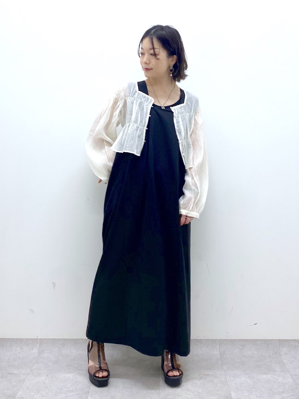 ブラック系のジャンパースカート、ホワイト系のシャツ/ブラウス、その他のサンダルを着用したレディースの夏コーディネートの1枚目の写真