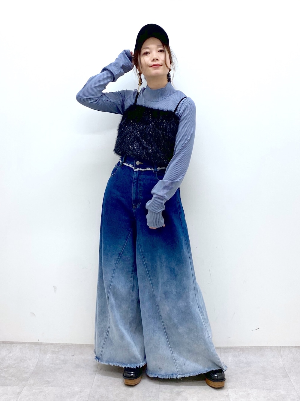 ブルー系のデニムパンツ、ブラック系のベスト、ブルー系のTシャツ/カットソーを着用したレディースの秋コーディネートの1枚目の写真