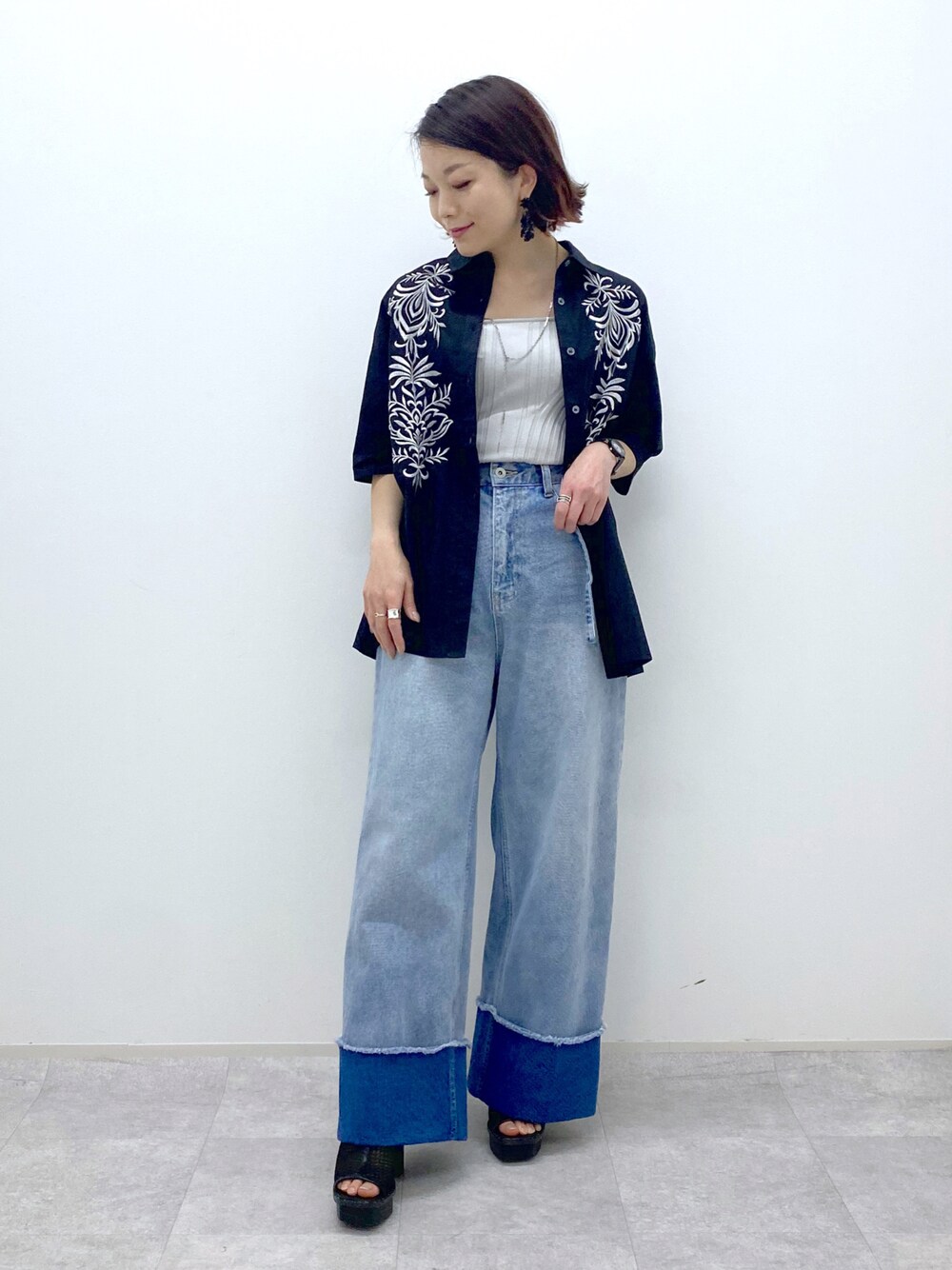 ブルー系のデニムパンツ、ブラック系のシャツ/ブラウス、ベージュ系のタンクトップを着用したレディースの春コーディネートの1枚目の写真