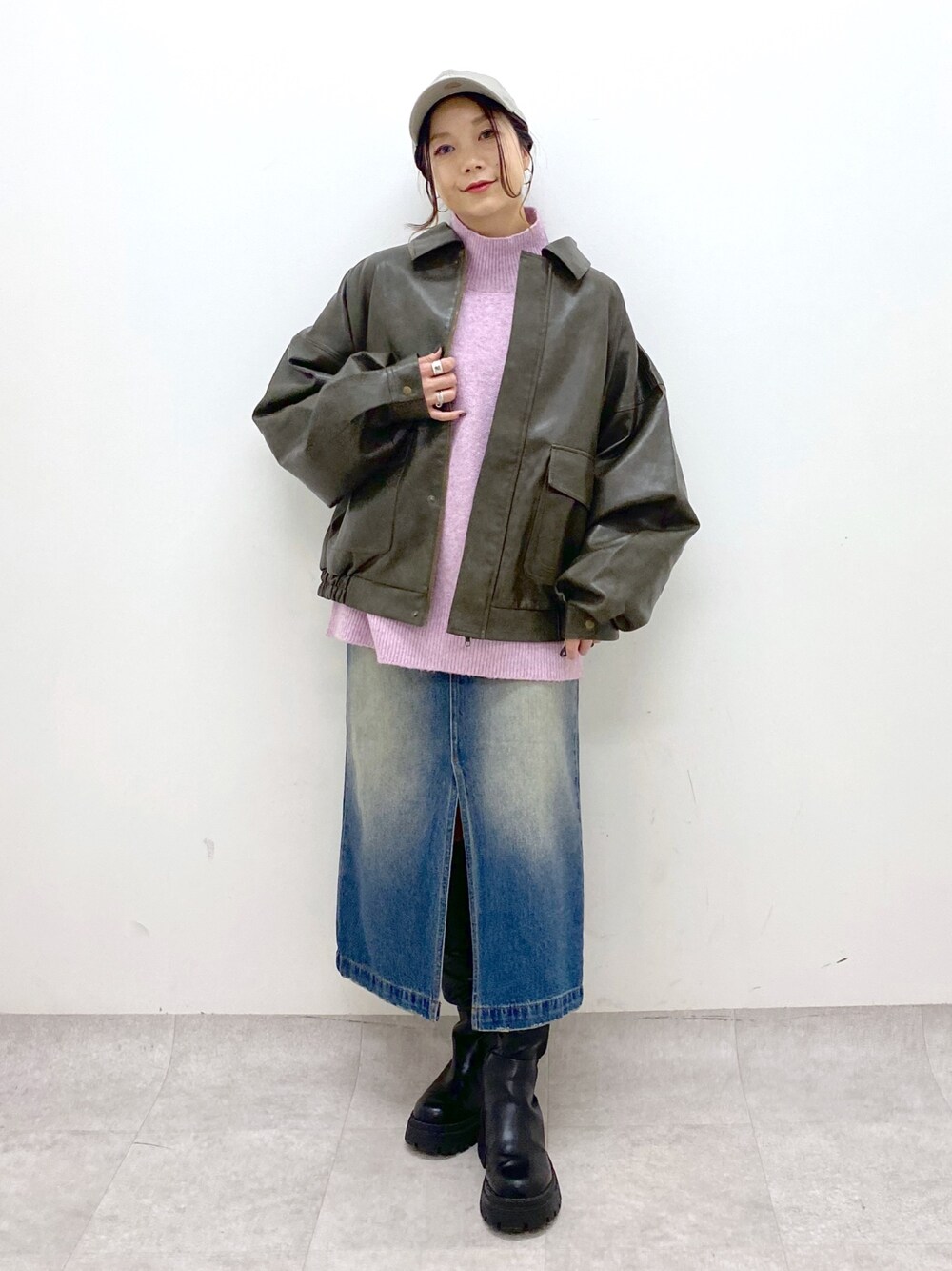 レッド系のニット/セーター、ブルー系のスカート、ブラック系のブーツを着用したレディースの秋コーディネートの1枚目の写真