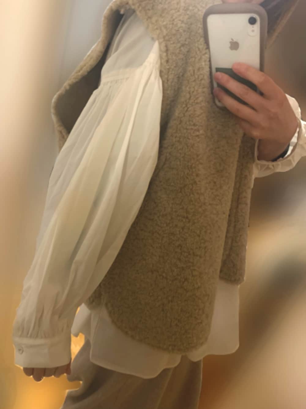 ベージュ系のベスト、ホワイト系のシャツ/ブラウスを着用したレディースの春コーディネートの1枚目の写真