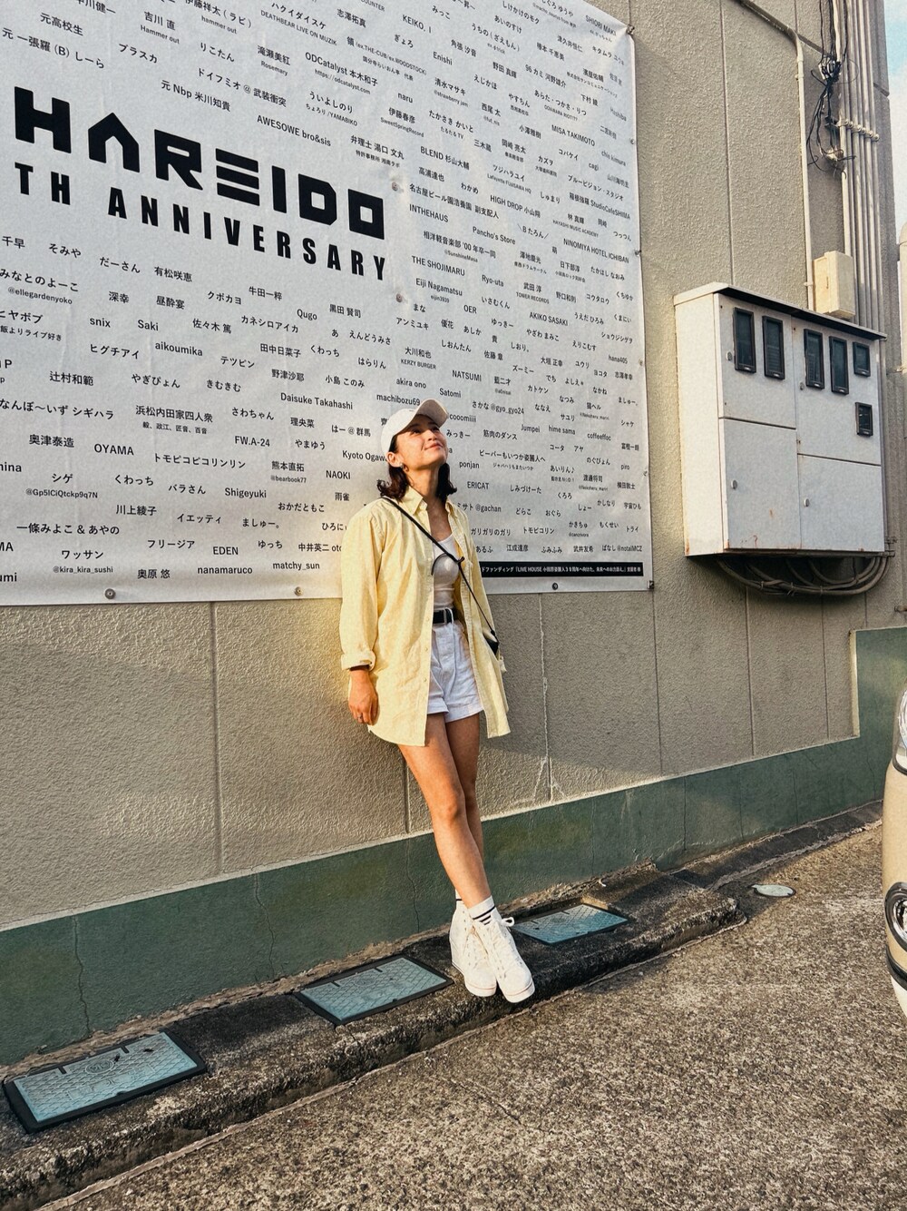 イエロー系のシャツ/ブラウス、ホワイト系のパンツ、ホワイト系のキャップを着用したレディースの秋コーディネートの1枚目の写真