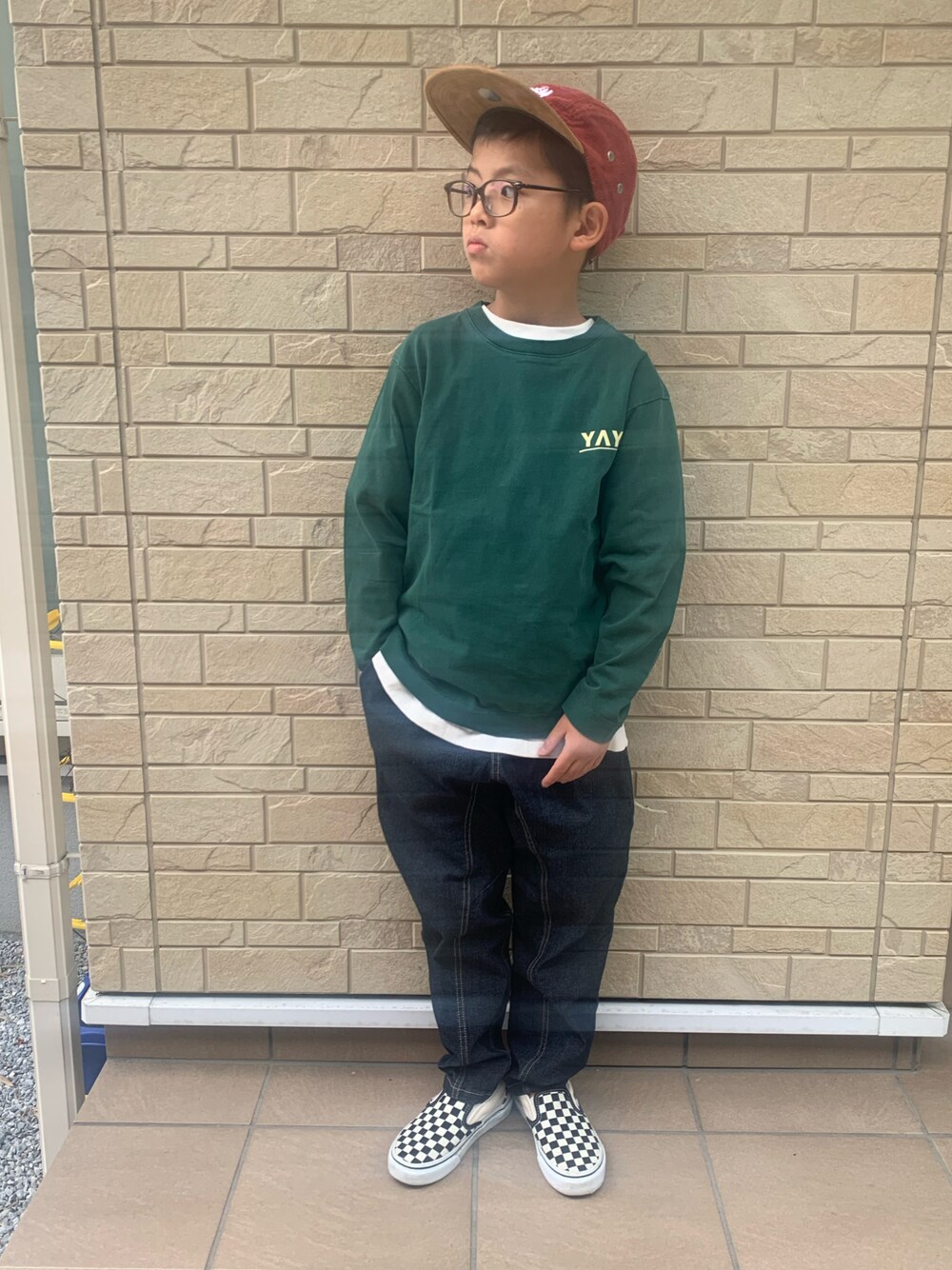 グリーン系のTシャツ/カットソー、ブルー系のデニムパンツを着用したキッズの秋コーディネートの1枚目の写真