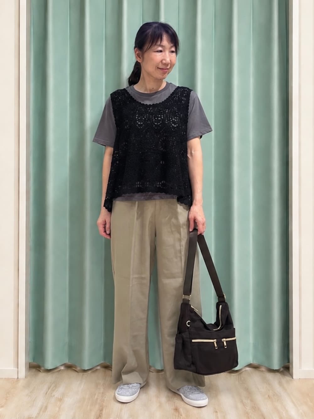 グリーン系のその他パンツ、シルバー系のその他シューズ、ブラウン系のショルダーバッグを着用したレディースの秋コーディネートの1枚目の写真