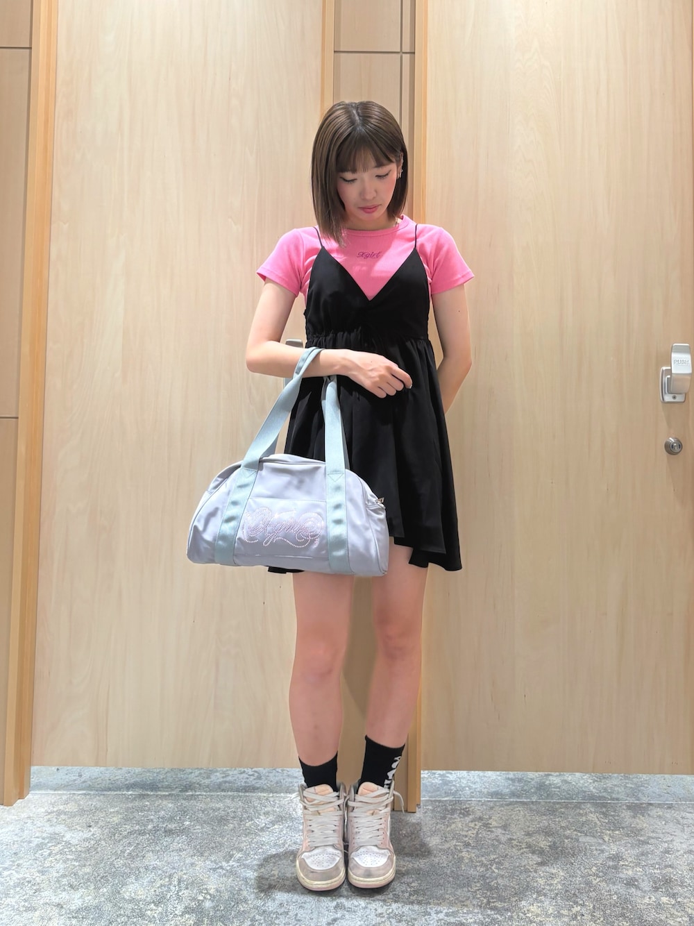 ブラック系のワンピース、ピンク系のTシャツ/カットソー、グレー系のハンドバッグを着用したレディースの夏コーディネートの1枚目の写真