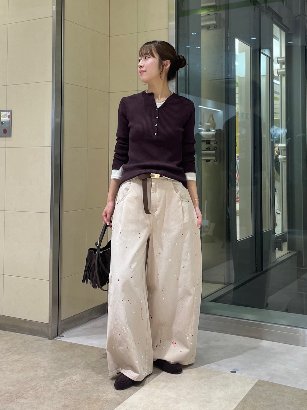 ベージュ系のその他パンツ、ホワイト系のTシャツ/カットソー、ブラウン系のニット/セーターを着用したレディースの秋コーディネートの1枚目の写真