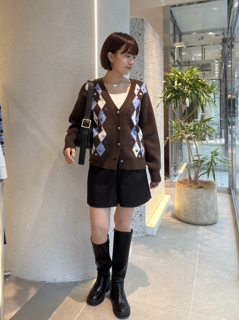 ブラウン系のカーディガン/ボレロ、ブラック系のショルダーバッグ、ブラック系のその他パンツを着用したレディースの秋コーディネートの1枚目の写真