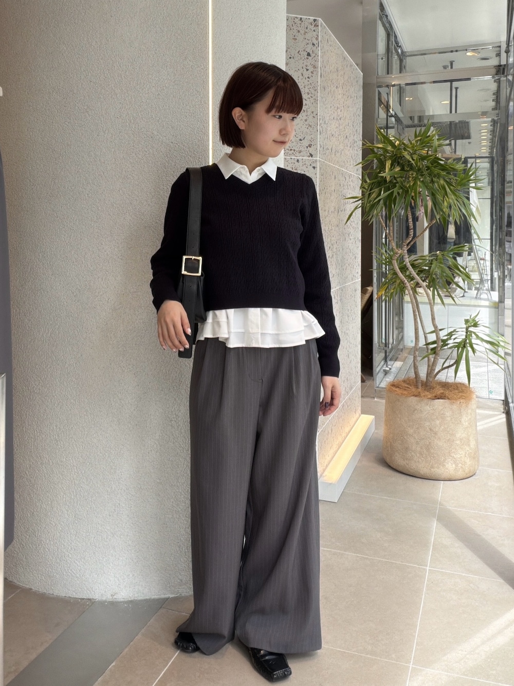 ホワイト系のシャツ/ブラウス、ブルー系のニット/セーター、ブラック系のショルダーバッグを着用したレディースの秋コーディネートの1枚目の写真