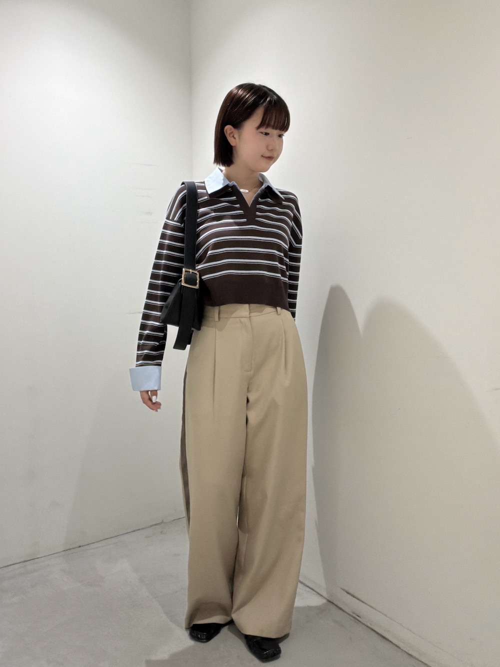 ブラウン系のニット/セーター、ブラック系のショルダーバッグ、ベージュ系のその他パンツを着用したレディースの夏コーディネートの1枚目の写真
